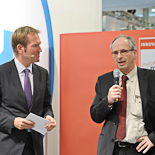 Vor der Ehrung des Gesamtsiegers des INNOVATIONSPREIS-IT 2011: Moderator Markus Brock (li., SWR) im Gespräch mit Prof. Dr. Stork (re., Karlsruher Institut für Technologie, Juror der Kategorie „Mobile“).